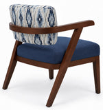 A mid-century modern accent chair with a dark brown wooden frame, a navy blue velvet seat cushion, and a patterned blue and white ikat cushion on the backrest, shown against a white background.