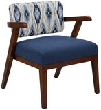 A mid-century modern accent chair with a dark brown wooden frame, a navy blue upholstered seat cushion, and a blue and white ikat patterned backrest cushion, shown on a white background.
