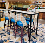 Bar stools with blue seats and patterned backs in a modern office setting.