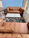 Brown leather sofa and coffee table in a club room with a geometric patterned rug.