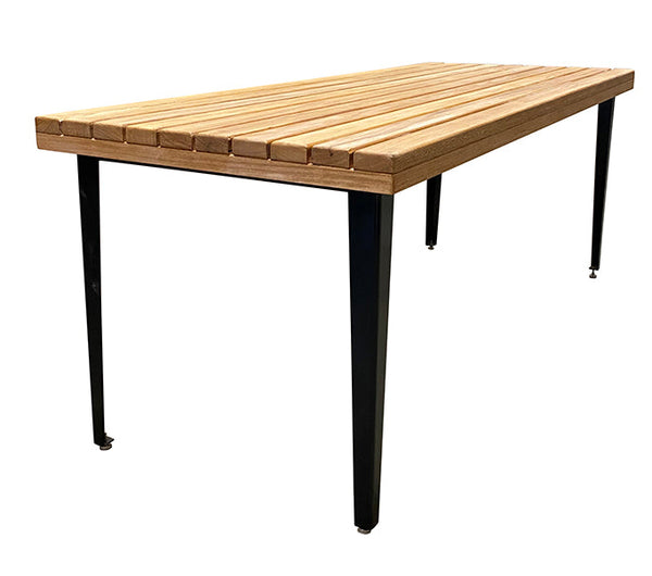 A rectangular dining table with a spotted gum timber top and powder coated steel frame with adjustable feet.